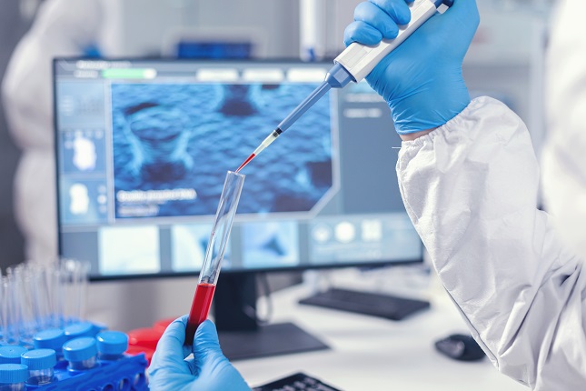 Medical researcher dripping blood into a test tube